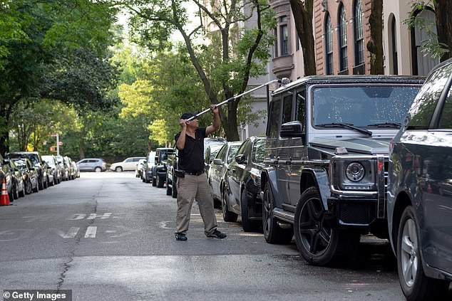 A man washes a Mercedes G- Class on a deserted street on Manhattan